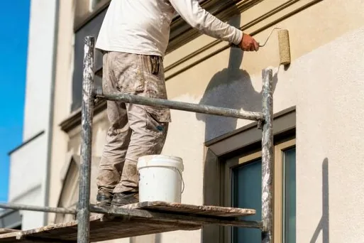 Crew on scaffolding applying elastomeric coating to stucco in Northridge